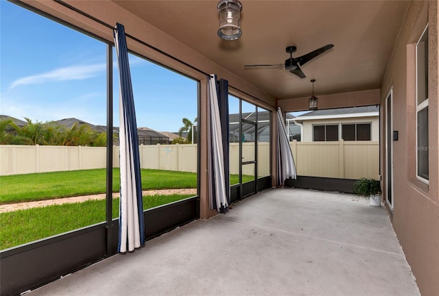 unfurnished sunroom featuring a mountain view and ceiling fan