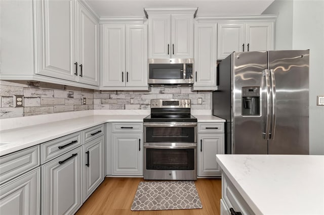 kitchen with white cabinetry, light wood-type flooring, and appliances with stainless steel finishes