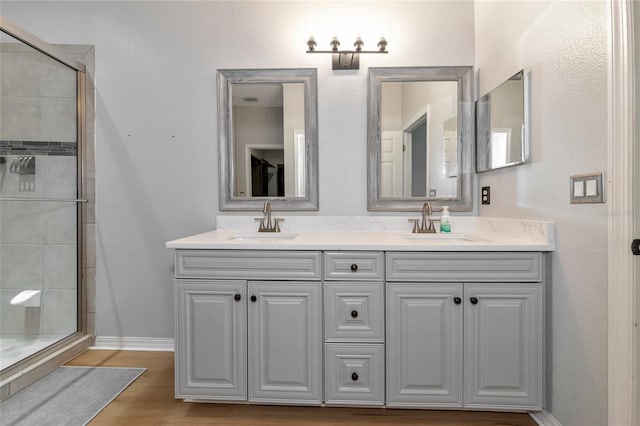 bathroom featuring hardwood / wood-style flooring, vanity, and an enclosed shower