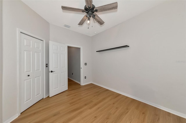 unfurnished bedroom with ceiling fan, a closet, and light wood-type flooring