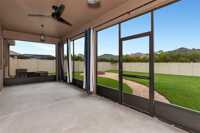 unfurnished sunroom featuring ceiling fan and a mountain view