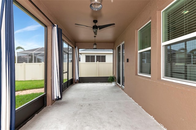 unfurnished sunroom featuring ceiling fan