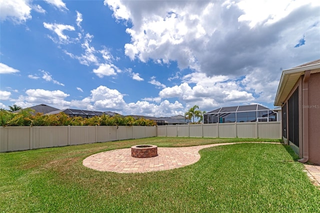 view of yard with a lanai, an outdoor fire pit, and a patio area