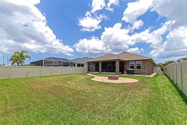 back of property featuring a lawn, a sunroom, and a patio