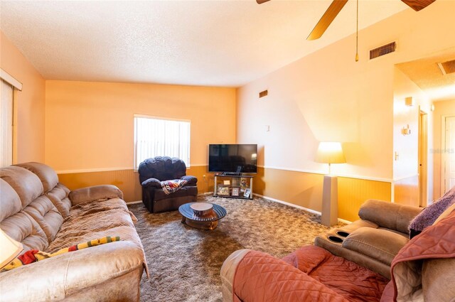 carpeted living room with ceiling fan, a textured ceiling, and vaulted ceiling