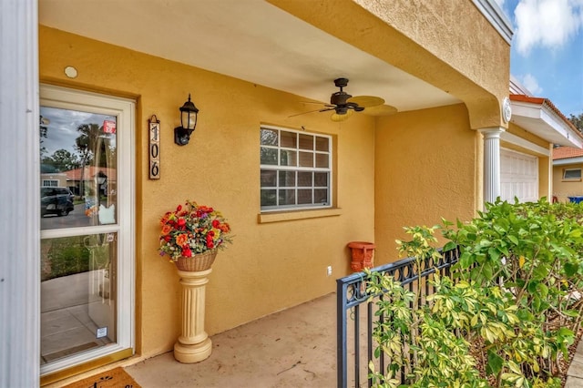 doorway to property with a garage and ceiling fan