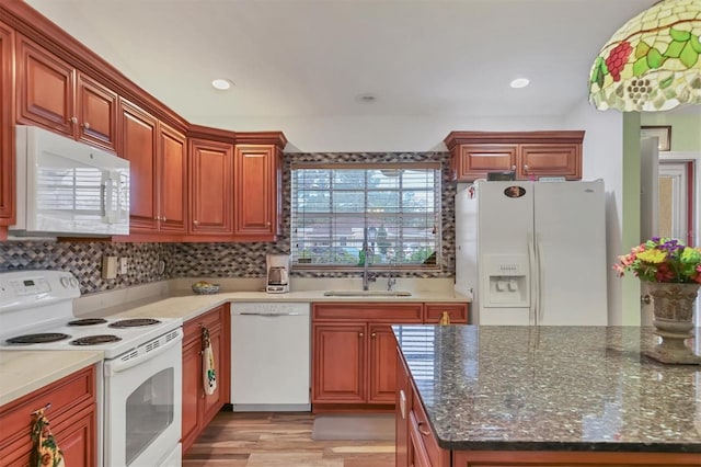 kitchen with light wood-type flooring, white appliances, sink, and a healthy amount of sunlight