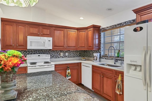 kitchen with tasteful backsplash, sink, white appliances, and vaulted ceiling