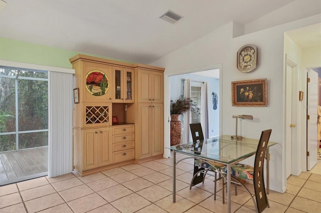 tiled dining area featuring lofted ceiling