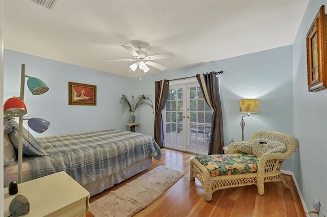 bedroom featuring ceiling fan, french doors, light hardwood / wood-style floors, and access to exterior