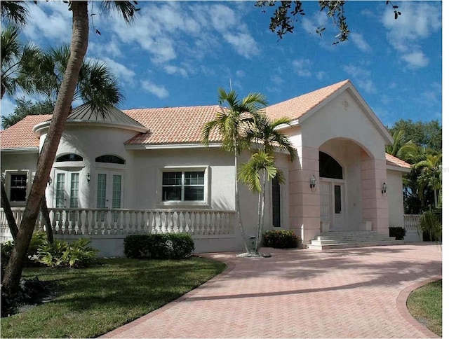 mediterranean / spanish house featuring a front yard and french doors