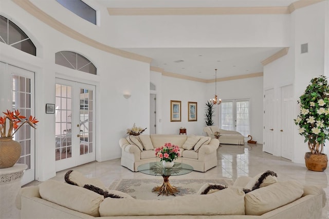 living room with crown molding, french doors, a towering ceiling, and a notable chandelier