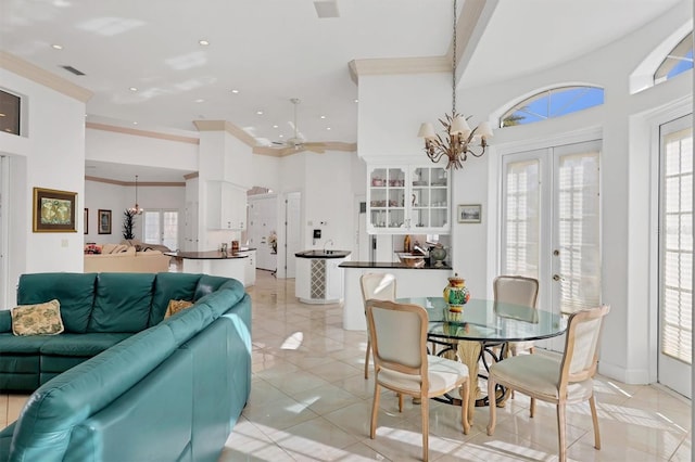 tiled dining space featuring ceiling fan with notable chandelier, a healthy amount of sunlight, crown molding, and french doors