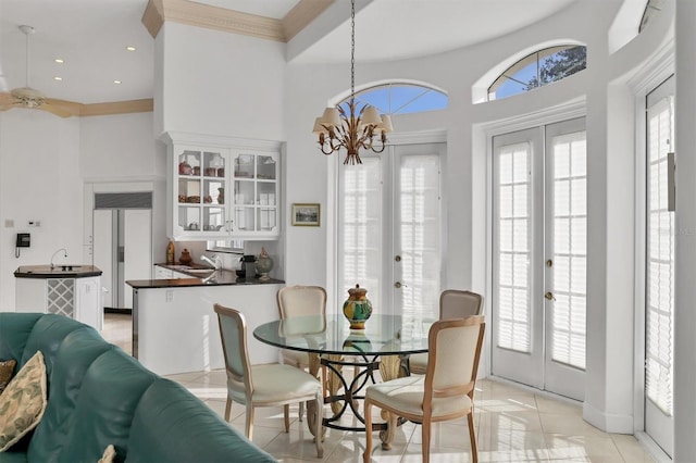 dining area with ornamental molding, french doors, sink, and an inviting chandelier