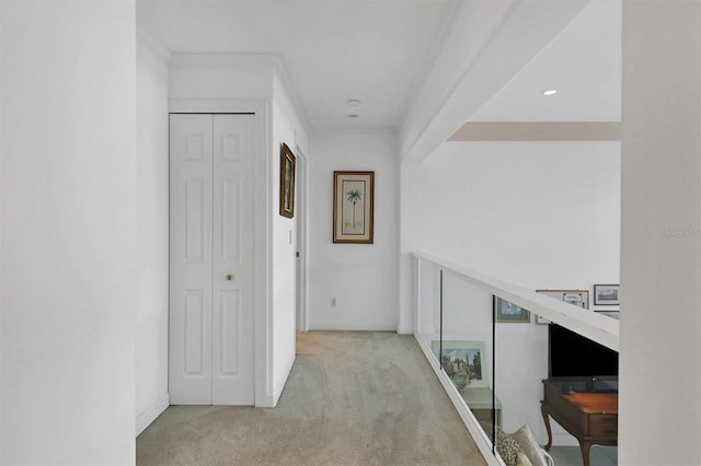 hall with light colored carpet and ornamental molding