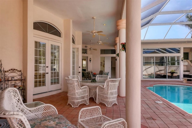 view of pool with glass enclosure, ceiling fan, a patio, and french doors