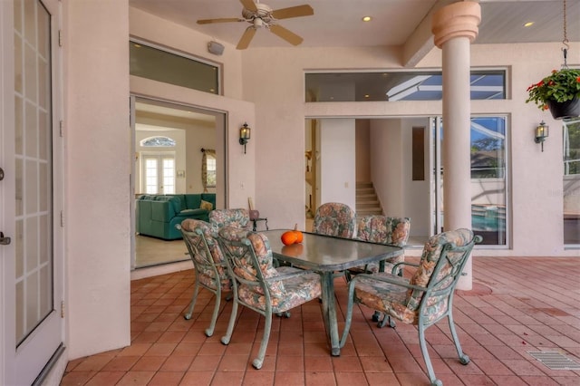 tiled dining room featuring ceiling fan and french doors