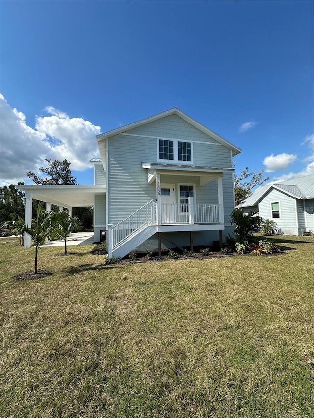 view of front of property with a front yard, a carport, and a porch