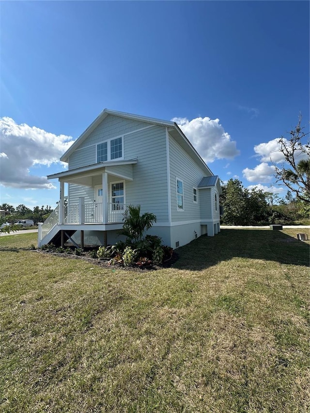 view of side of home with a yard and covered porch