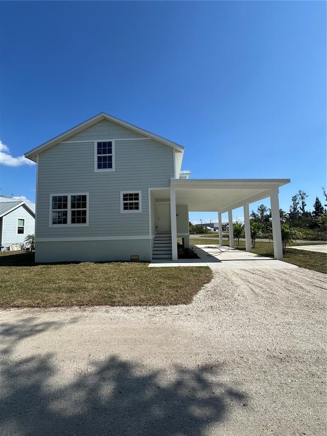 view of front of home with a front yard and a carport