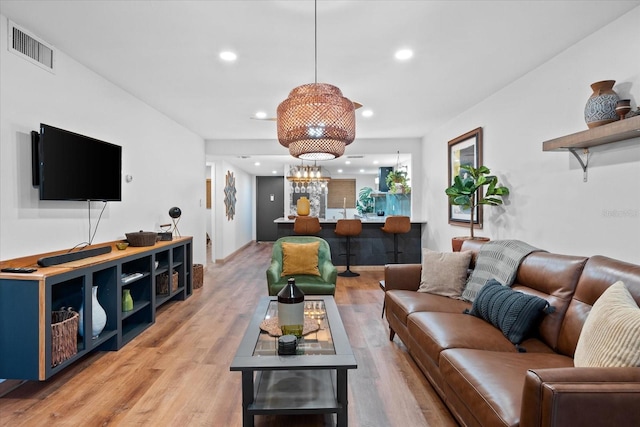 living room featuring an inviting chandelier and light wood-type flooring