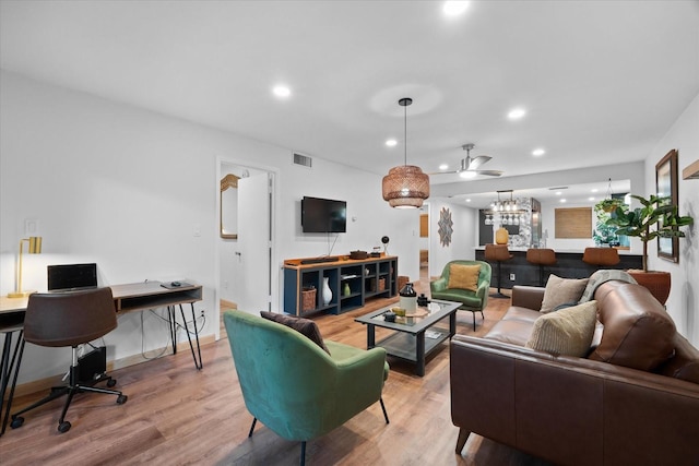 living room with light hardwood / wood-style flooring and ceiling fan