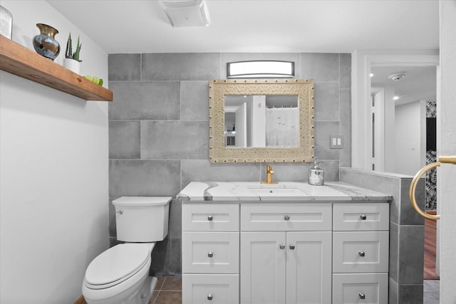 bathroom with vanity, tile walls, and toilet