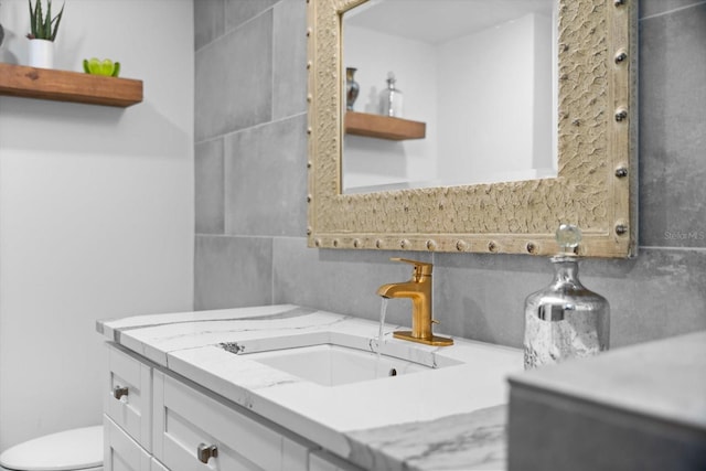 bathroom featuring vanity, backsplash, and toilet