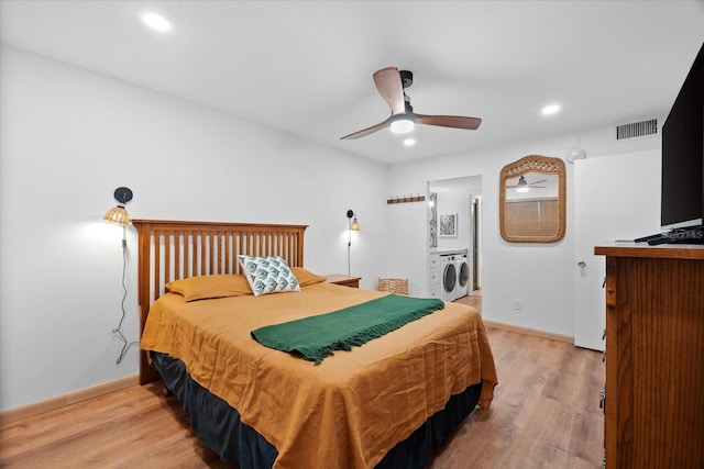 bedroom with washer and dryer, light hardwood / wood-style flooring, and ceiling fan