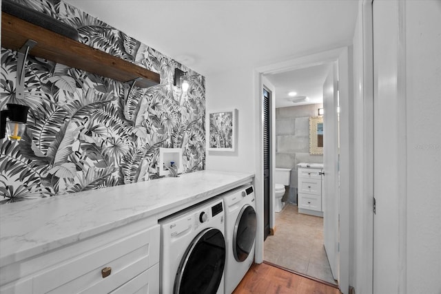 laundry room featuring washer and dryer and light hardwood / wood-style flooring