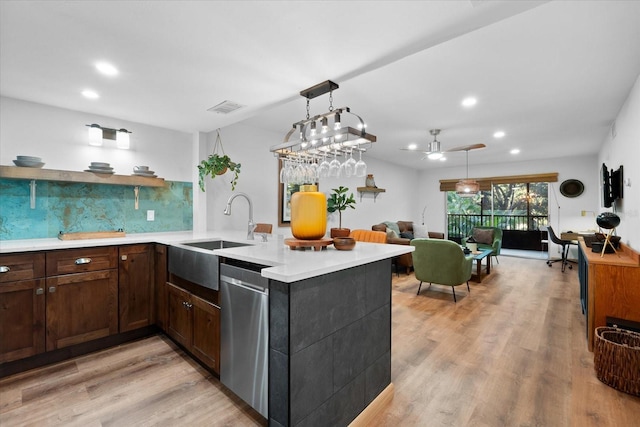 kitchen with tasteful backsplash, kitchen peninsula, ceiling fan, and stainless steel dishwasher