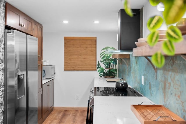 3700 S Osprey Ave Unit 214, Sarasota, FL 34239 - kitchen with stainless steel fridge with ice dispenser, light wood finished floors, recessed lighting, white microwave, and range hood