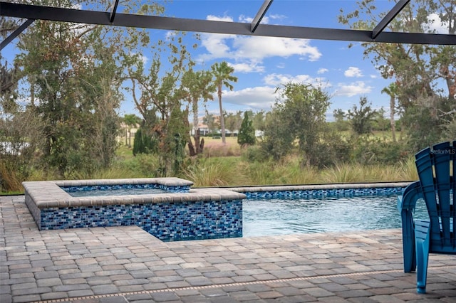 view of swimming pool featuring glass enclosure, a jacuzzi, and a patio area