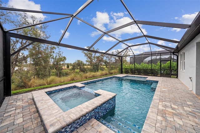 view of pool featuring an in ground hot tub, a patio area, and a lanai