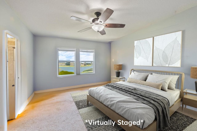 carpeted bedroom with a textured ceiling and ceiling fan