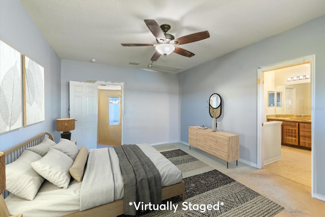 bedroom with ceiling fan, ensuite bath, and light colored carpet