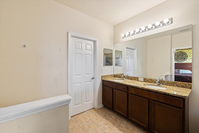 bathroom featuring tile patterned floors, vanity, a textured ceiling, and toilet