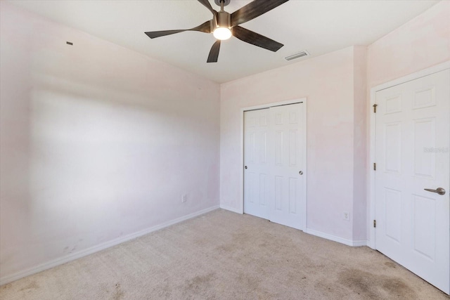 unfurnished bedroom featuring light carpet, ceiling fan, and a closet