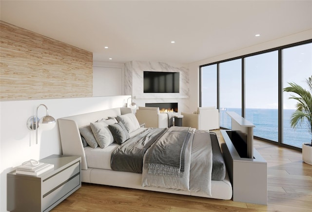 bedroom with access to exterior, light hardwood / wood-style floors, a water view, and a premium fireplace