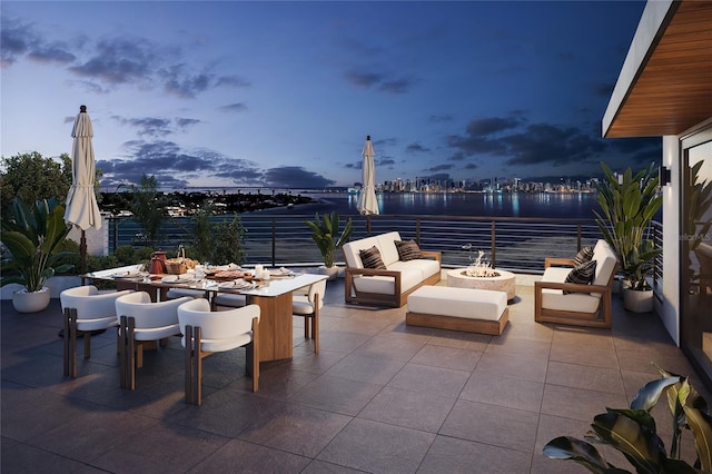 3200 Higel Ave, Sarasota, FL 34242 - patio terrace at dusk featuring a patio, a water view, an outdoor living space with a fire pit, and outdoor dining area