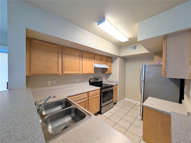 kitchen featuring stainless steel appliances, sink, light brown cabinets, a textured ceiling, and light tile patterned floors