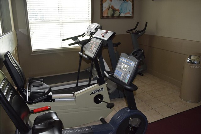 workout room featuring a wealth of natural light and light tile patterned flooring