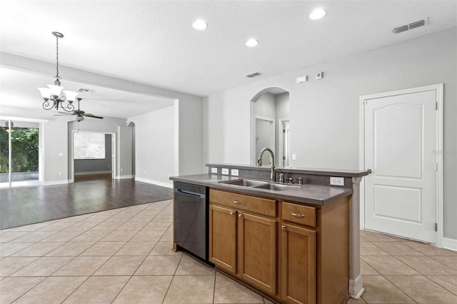 kitchen with light hardwood / wood-style floors, hanging light fixtures, sink, an island with sink, and stainless steel dishwasher