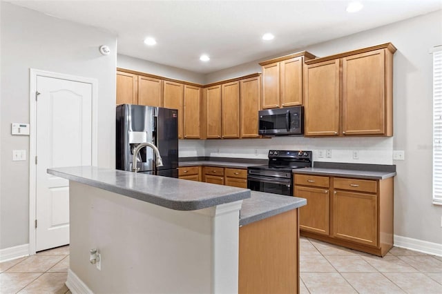 kitchen with sink, a kitchen island with sink, light tile patterned floors, and stainless steel appliances