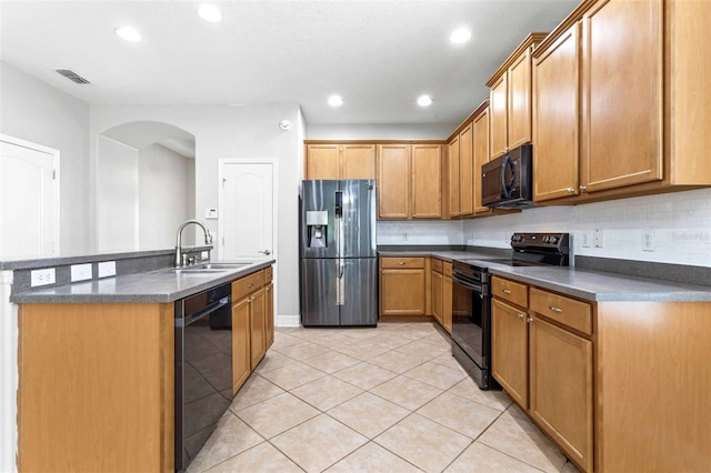 kitchen with black appliances, light tile patterned floors, decorative backsplash, sink, and an island with sink