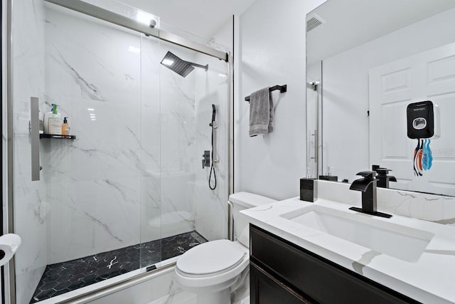 bathroom featuring vanity, toilet, and a shower with door