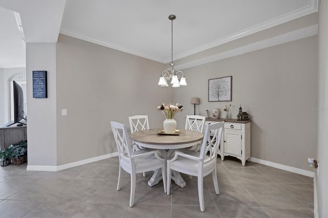 tiled dining room with a notable chandelier and ornamental molding