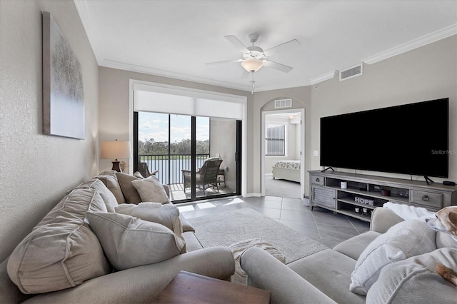 living room featuring ceiling fan, light tile patterned floors, and ornamental molding