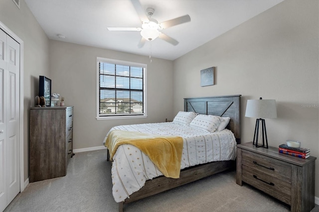 carpeted bedroom featuring ceiling fan and a closet