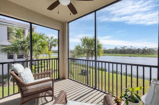 sunroom with a wealth of natural light, a water view, and ceiling fan